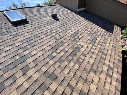 Completed architectural shingle roof plane with skylight and vent details