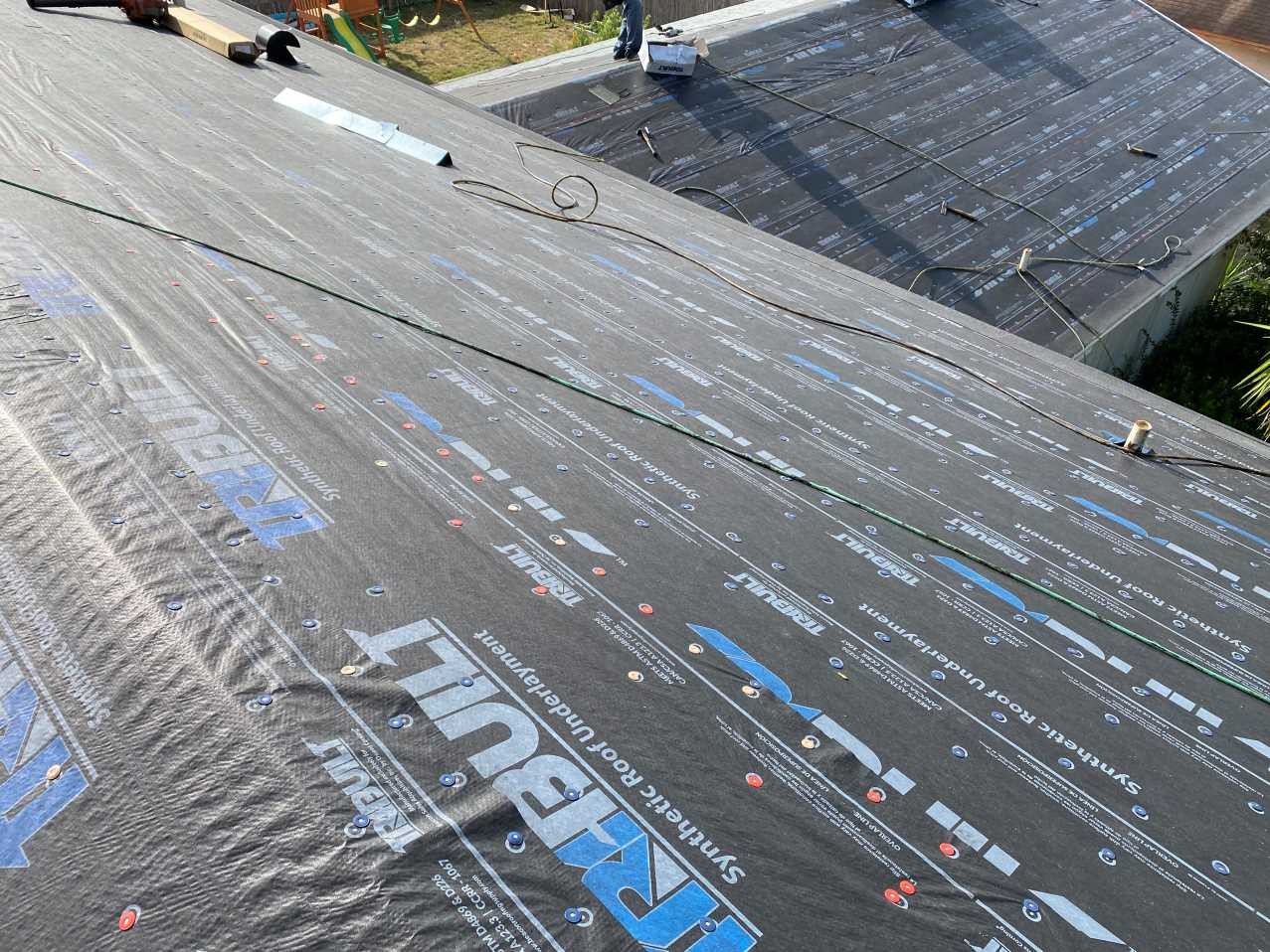 Synthetic underlayment installed across the roof field